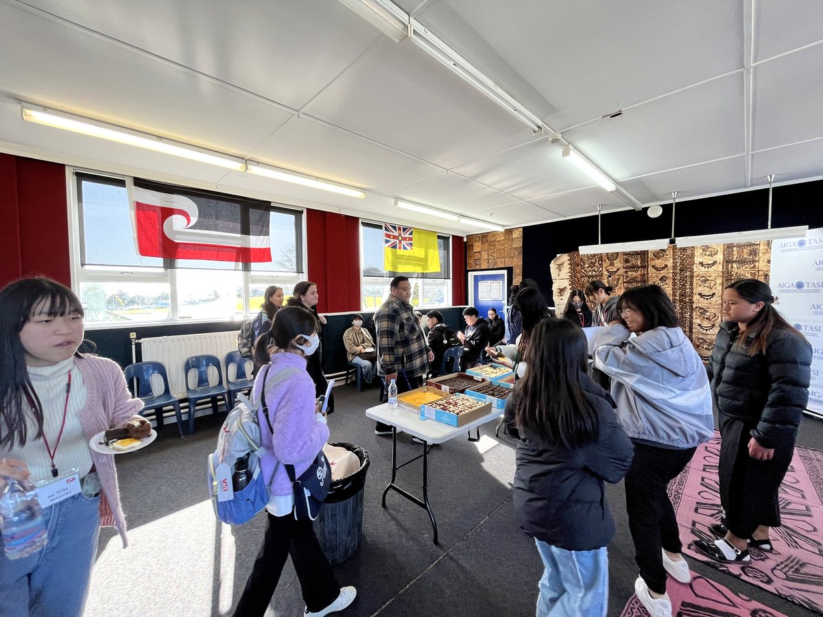 A lively indoor student gathering and cultural event featuring international students enjoying shared...