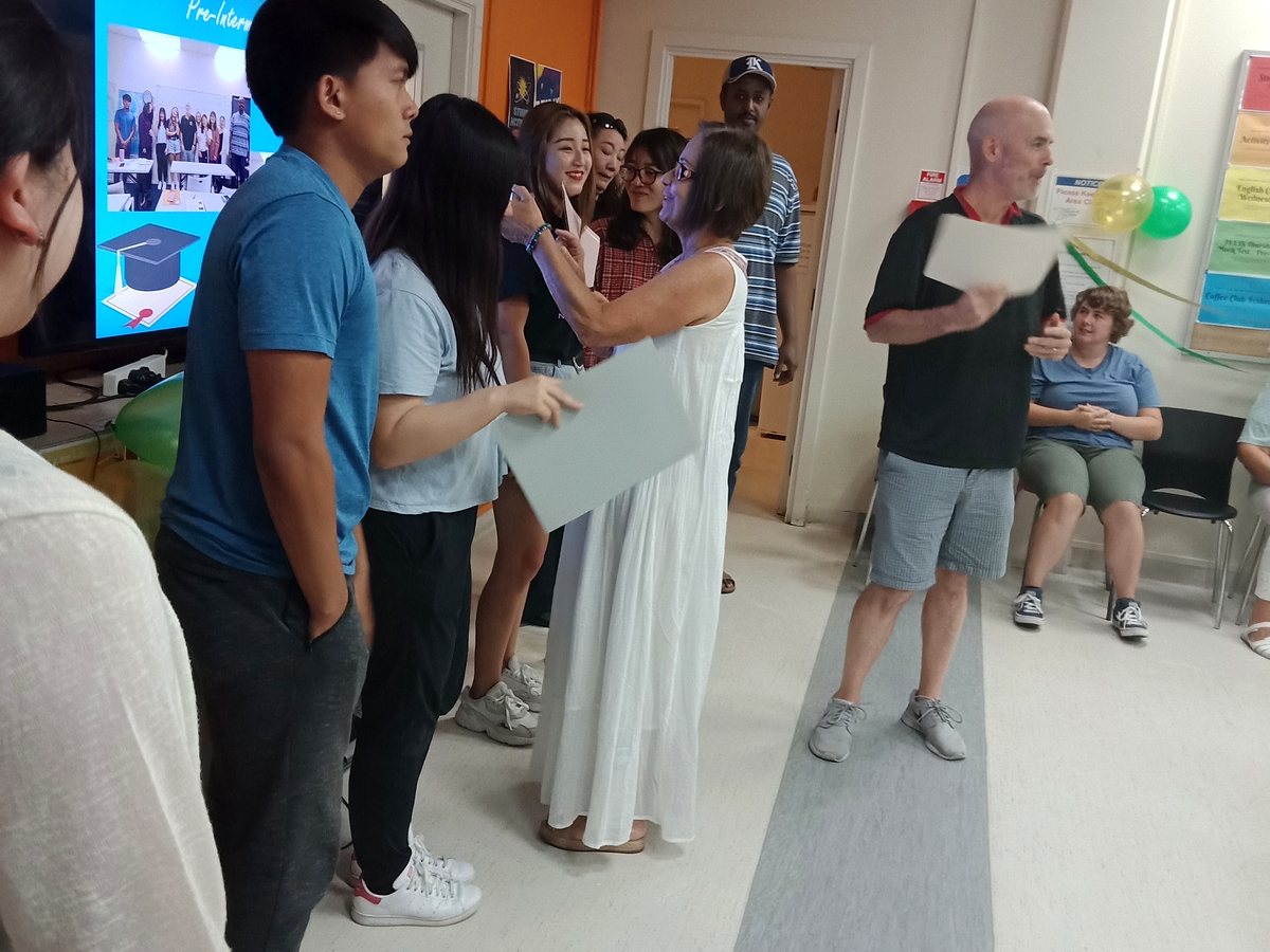 An authentic indoor shot of WIE staff members presenting certificates or course completion folders to a...