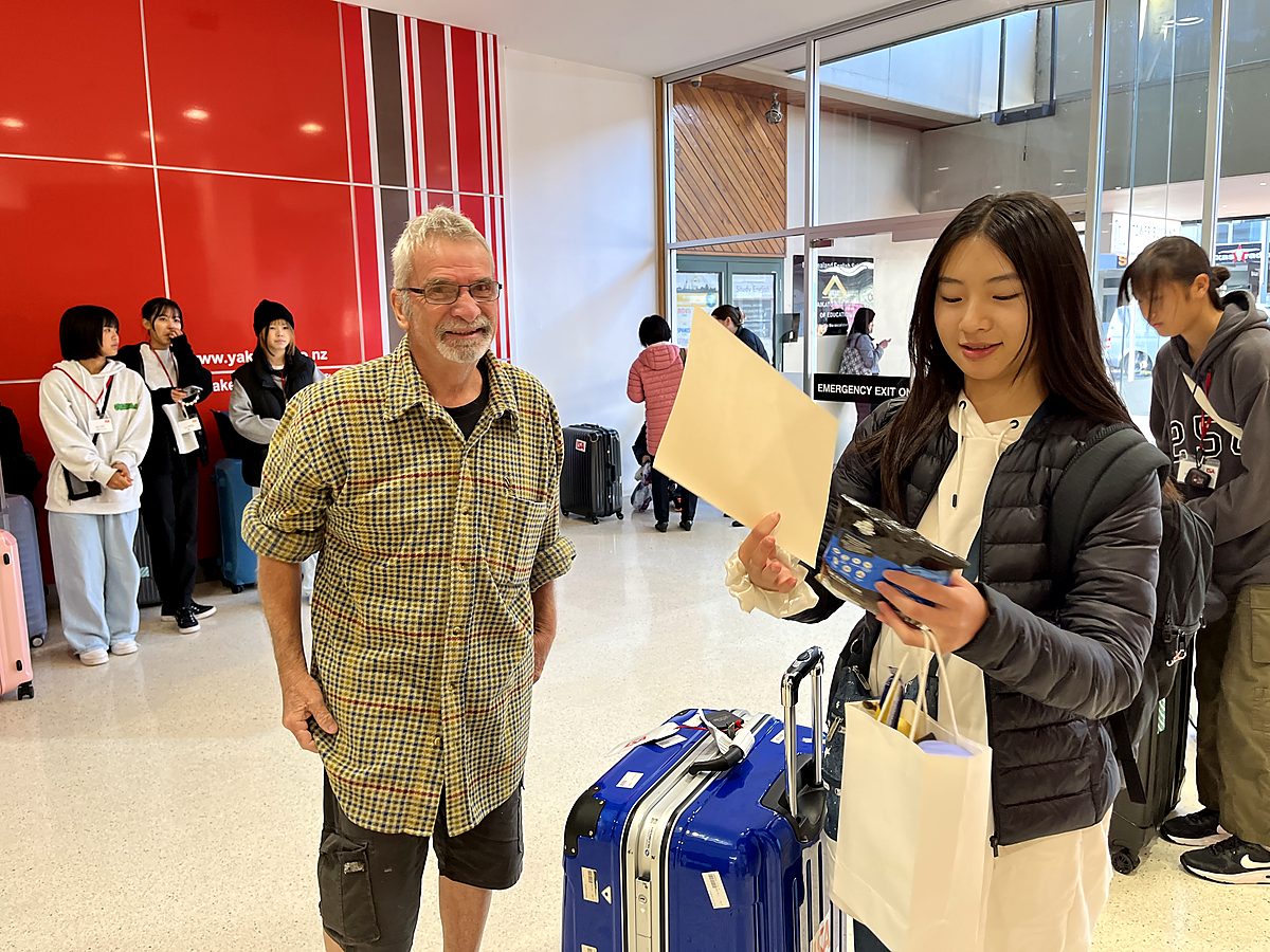 A student reviews welcome materials in a reception setting, showing arrival and support.