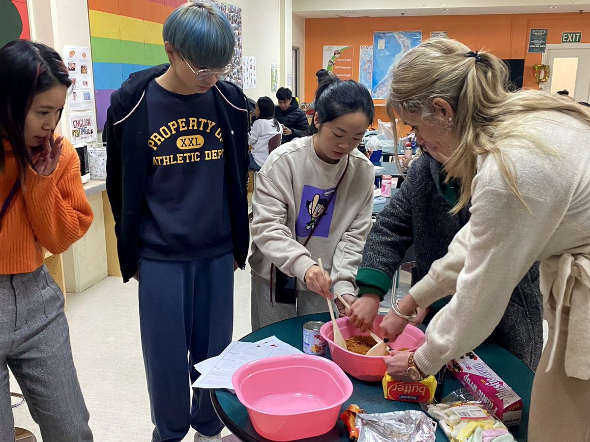 Students and staff participating in an interactive group activity around a table inside a WIE classroom...