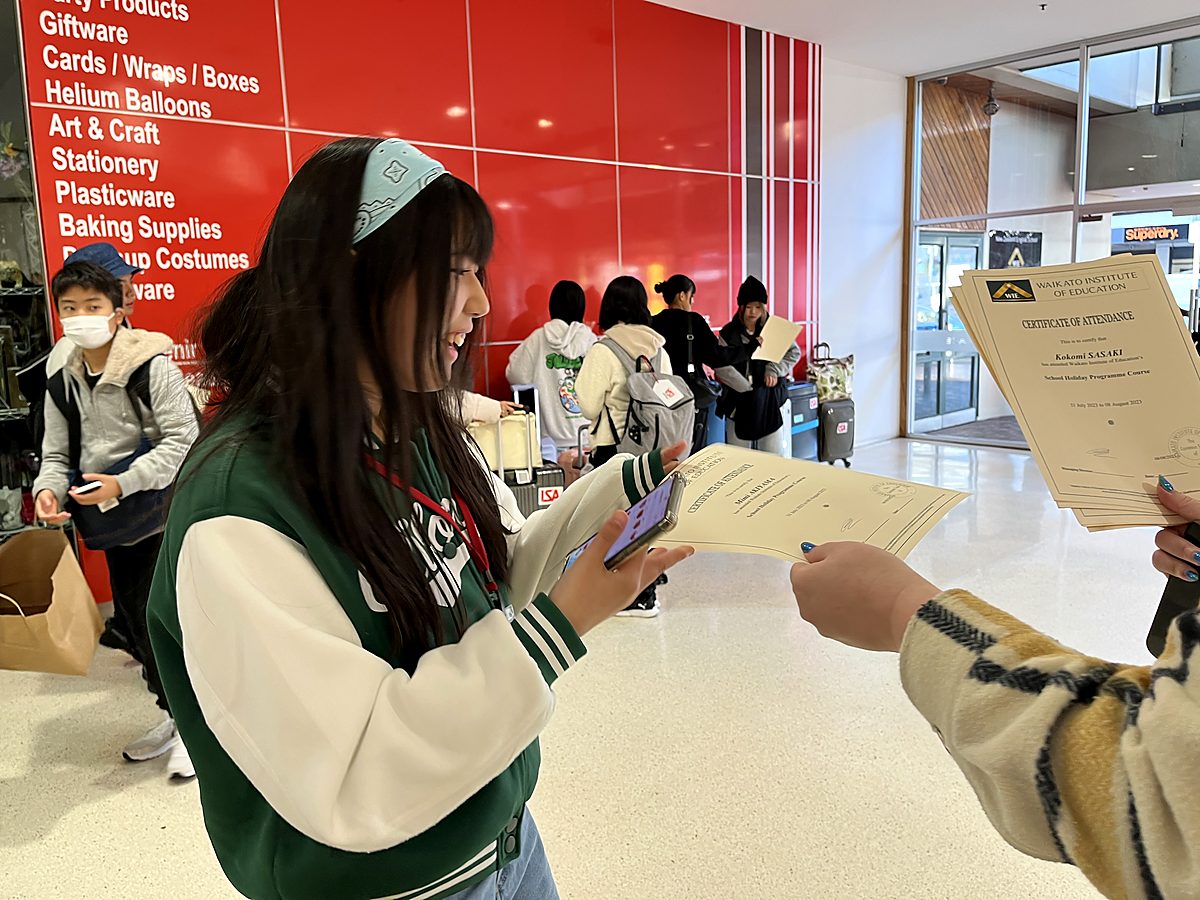 A student receives a WIE certificate, showing achievement as part of the study journey.